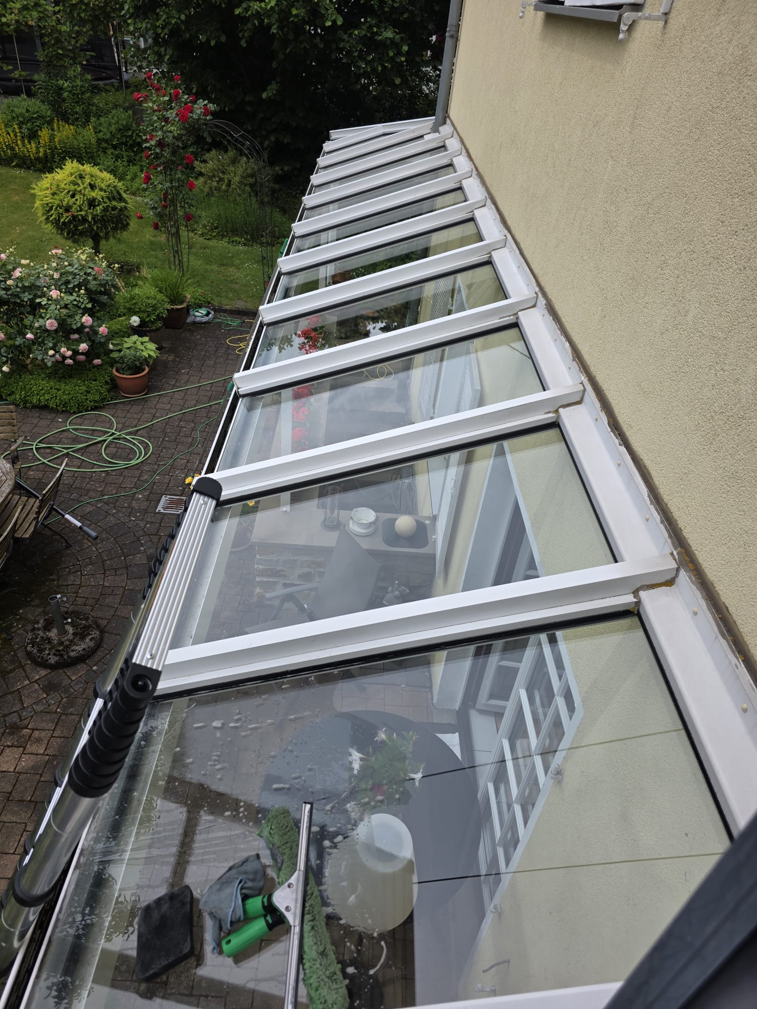 Reinigung eines verglasten Terrassendachs mit Einwascher und Abzieher